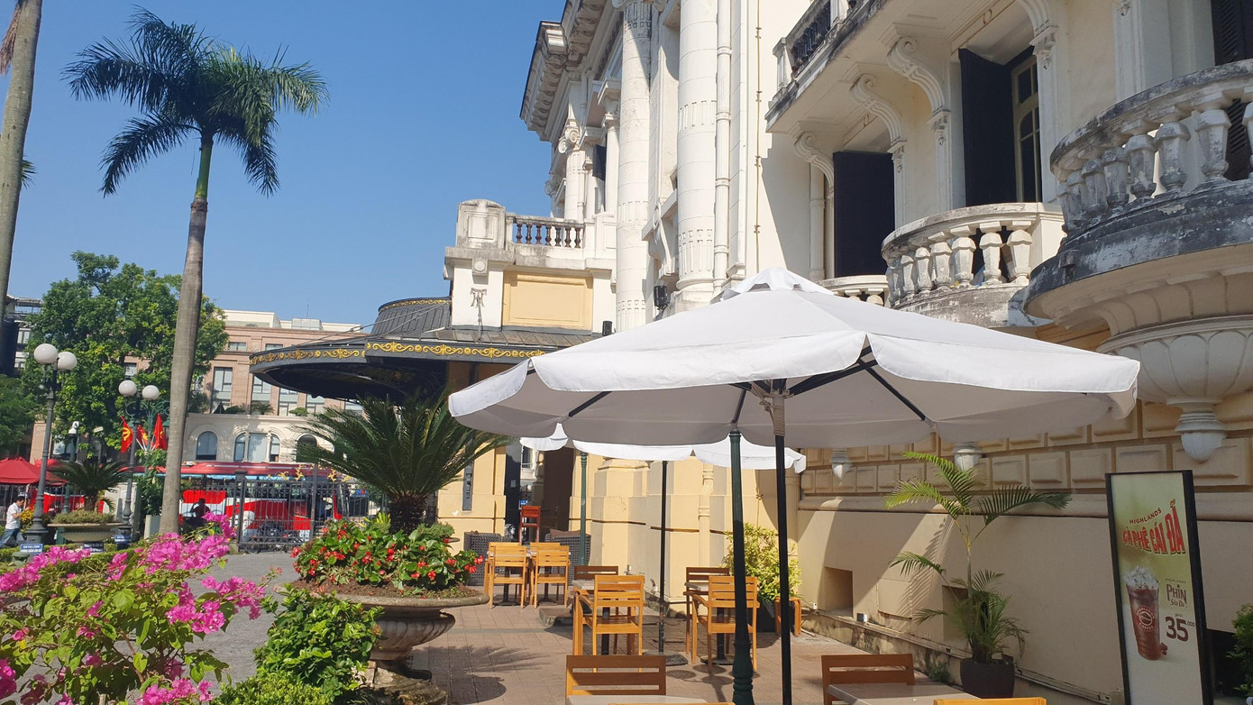 Khu vực vườn hoa Nhà hát Lớn Hà Nội nằm chếch phía tây nam là quán Highlands Coffee. Cổng trước phía hướng ra Quảng trường Cách mạng Tháng 8 đã khóa trái, khách muốn vào phải đi bằng một cửa riêng phía sau Nhà hát Lớn.