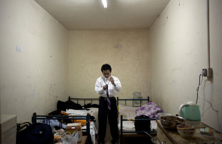 He Bing, 23 tuổi, thử chiếc áo sơ mi mới cùng chiếc cà vạt đi mượn đêm trước khi thi để trở thành người bán bảo hiểm, ngày 10-3-2011. Bing mới từ Trùng Khánh tới Bắc Kinh. Anh sống ở một căn phòng “ngầm” ở trung tâm Bắc Kinh cùng 2 người khác