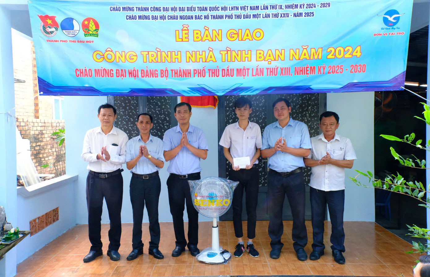 Em Lê Thanh Phúc nhận quà từ đại diện các đơn vị tại lễ bàn giao công trình "Nhà tình bạn".