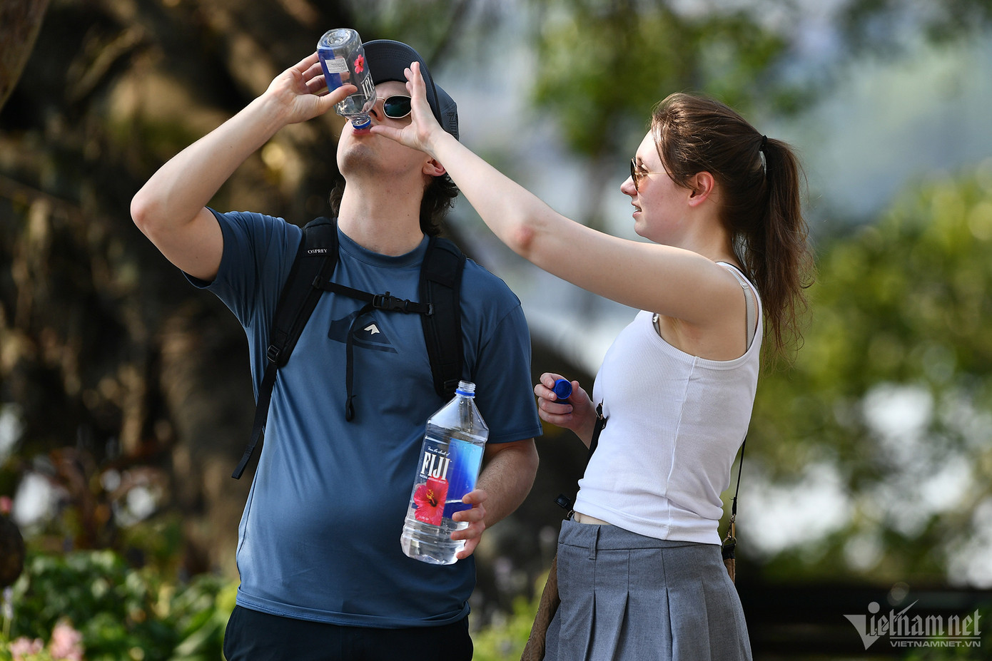 Hai du khách nước ngoài trong khi đi bộ bên hồ Gươm đã thay nhau tu hết 2 chai nước.