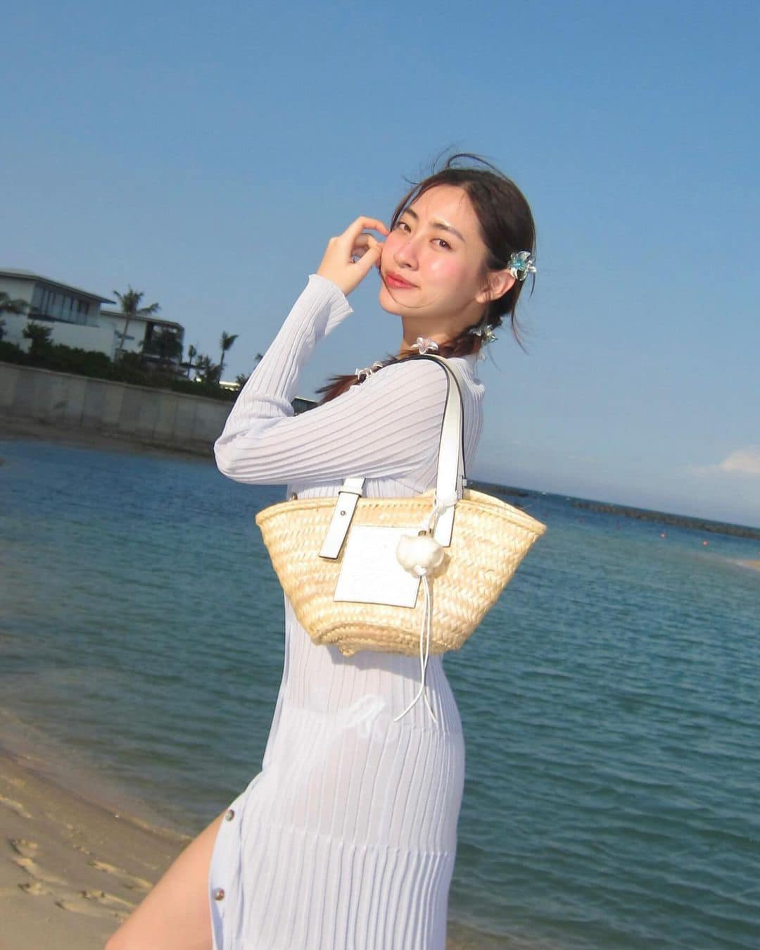 Hoa hậu Lương Thùy Linh diện váy tông màu trắng nhẹ nhàng khi đi du lịch biển dịp lễ.