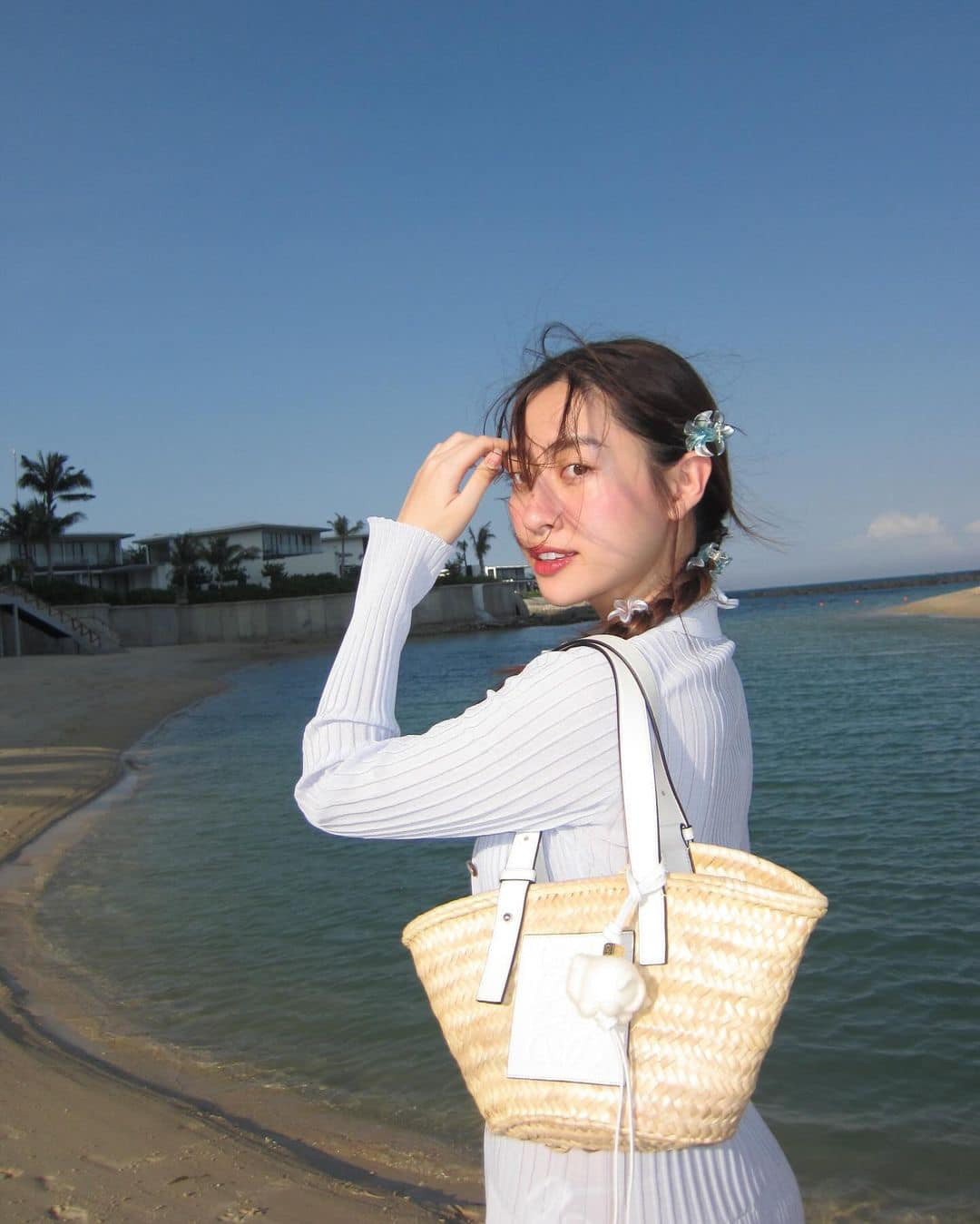 Hoa hậu Lương Thùy Linh diện váy tông màu trắng nhẹ nhàng khi đi du lịch biển dịp lễ.