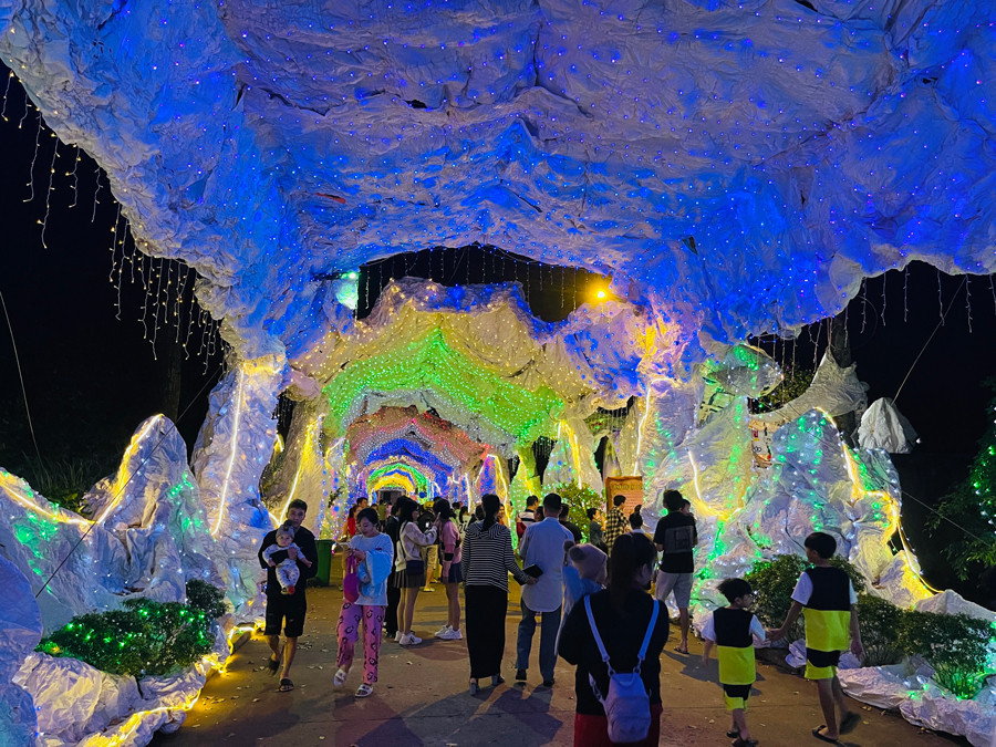 Các em nhỏ thích thú chụp ảnh với ông già Noel tại con đường hang đá. Ảnh: Huy Hoàng