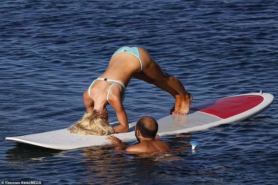 Cô tập yoga với sự hỗ trợ giữ thăng bằng chiếc ván của chồng. Cô tập yoga với sự hỗ trợ giữ thăng bằng chiếc ván của chồng.