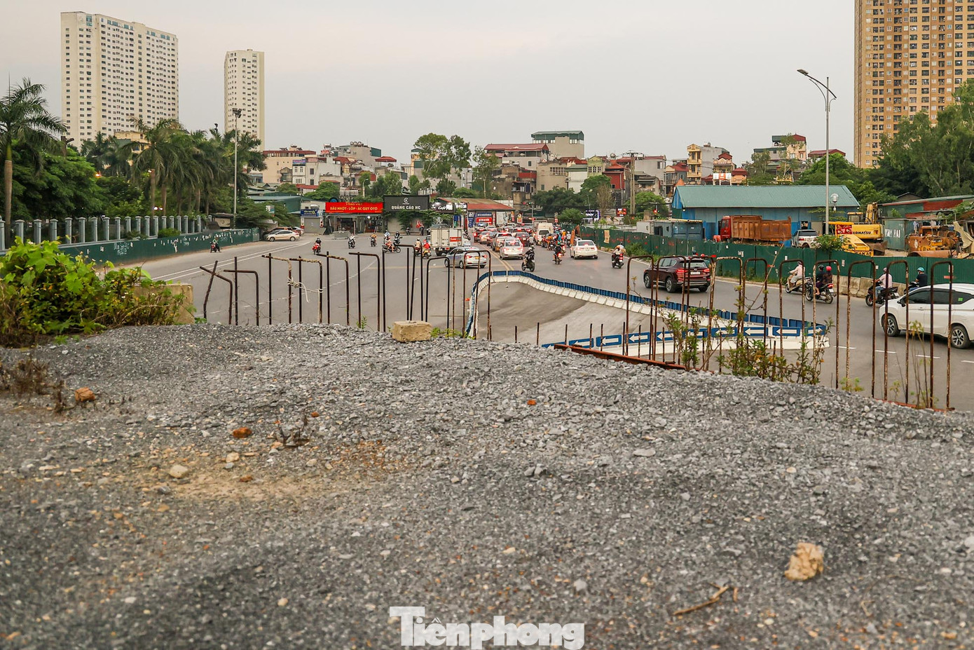 Phía dưới trụ cầu, rác sinh hoạt và phế liệu xây dựng chất thành đống, lối lên cầu vượt đang thi công dở, nay cây dại mọc leo đã phủ kín gần hết bề mặt.