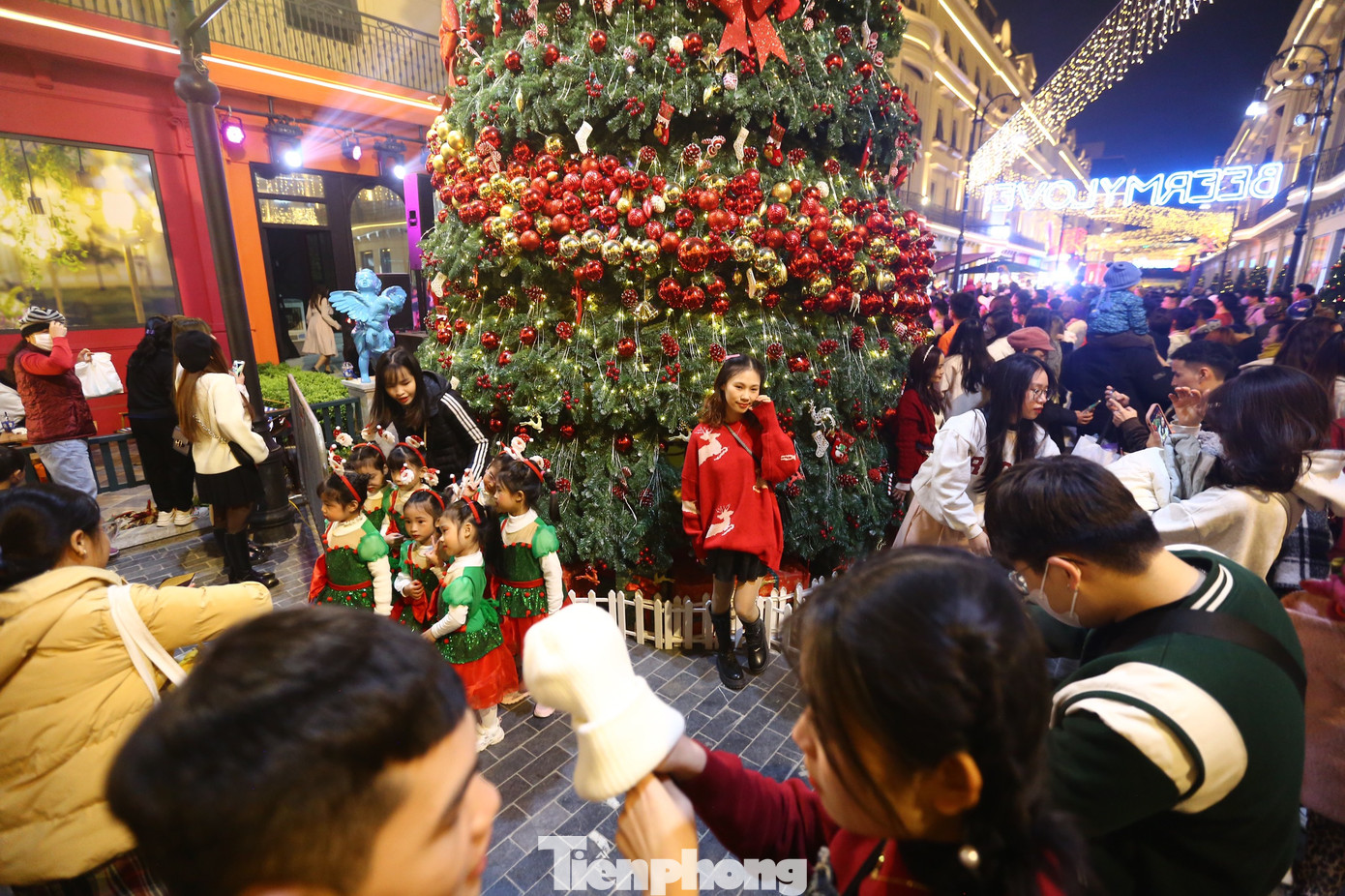 Khu vực cây thông đông đúc, chật kín người vây quanh để chụp ảnh.