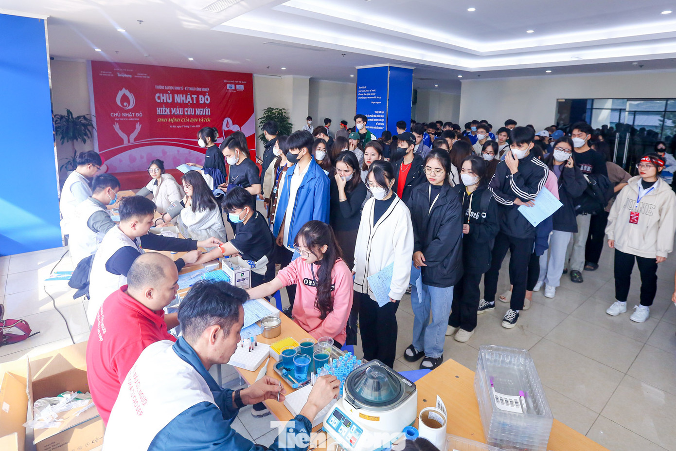 Hàng trăm sinh viên xếp hàng dài đăng ký, thực hiện các thao tác, thủ tục kiểm tra sức khỏe nhanh tại chương trình.