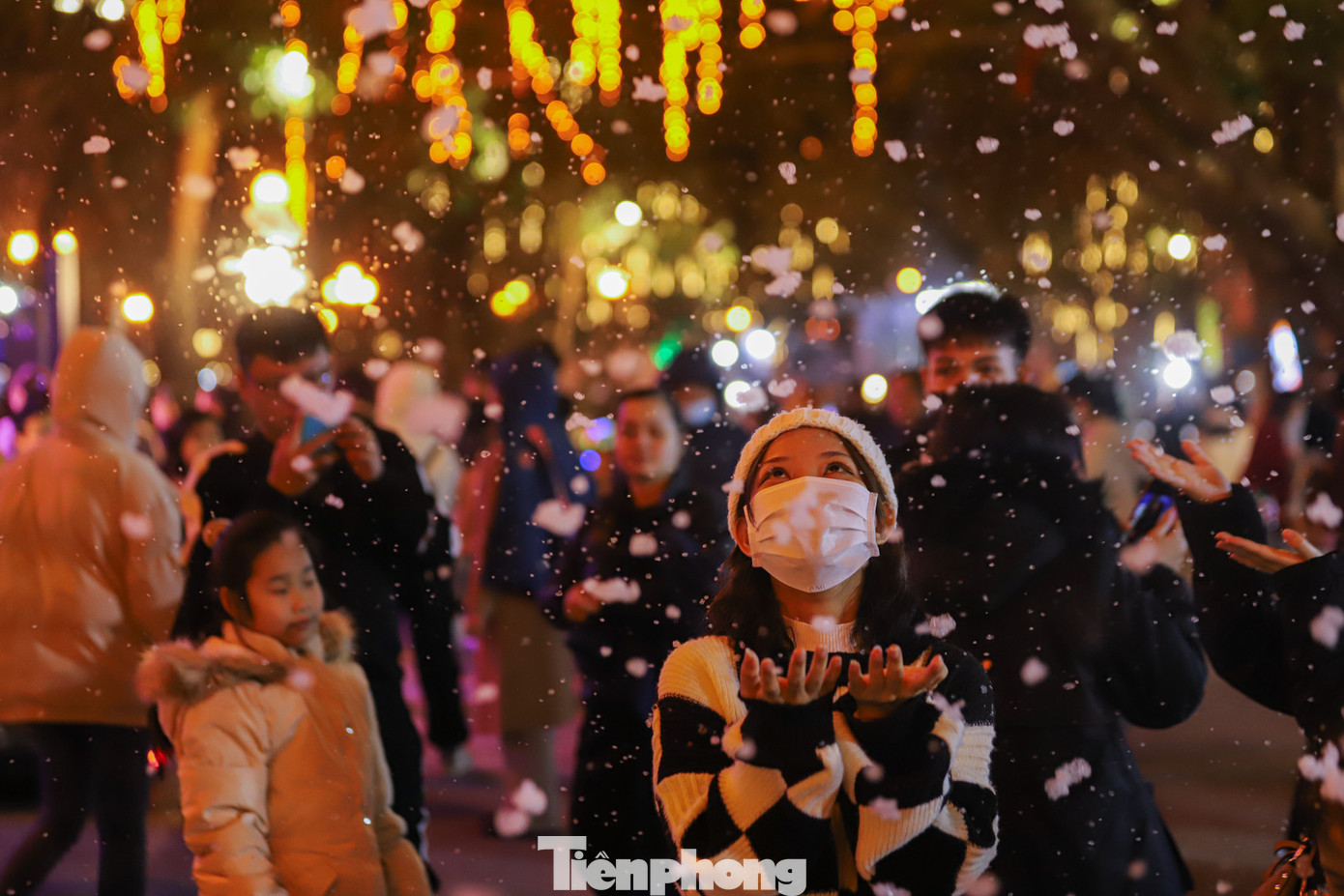 Bạn trẻ thích thú hứng những bông tuyết nhân tạo.