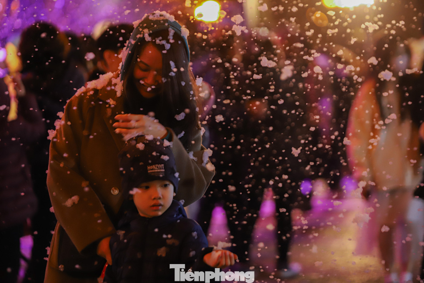 Người dân thích thú chụp ảnh cùng với những bông tuyết trắng...