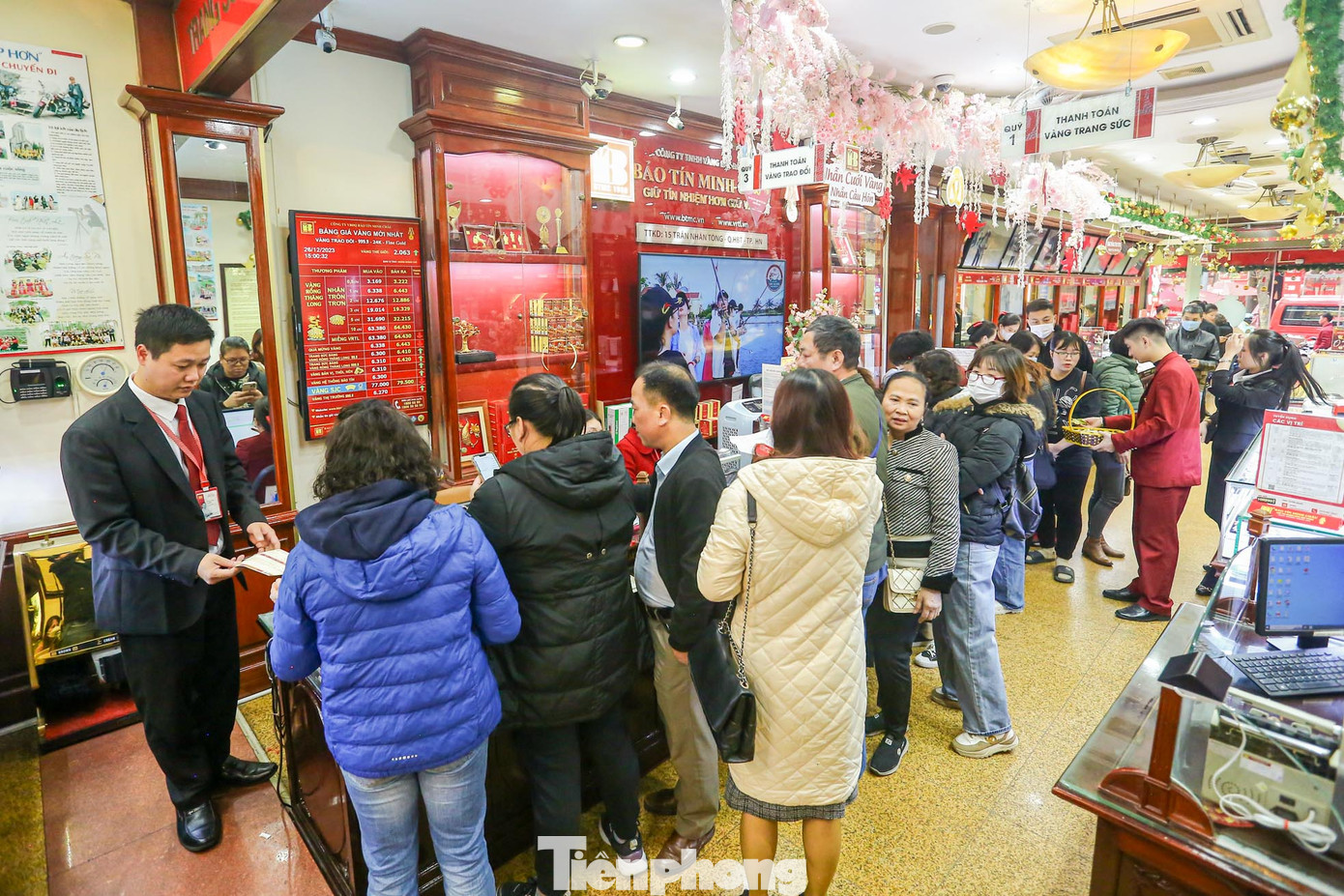 Ghi nhận của PV, đầu giờ chiều ngày 26/12, người dân xếp hàng mua bán vàng tại các cửa hàng, bảo tín trên phố Trần Nhân Tông khi giá vàng đang chao đảo trên đỉnh.