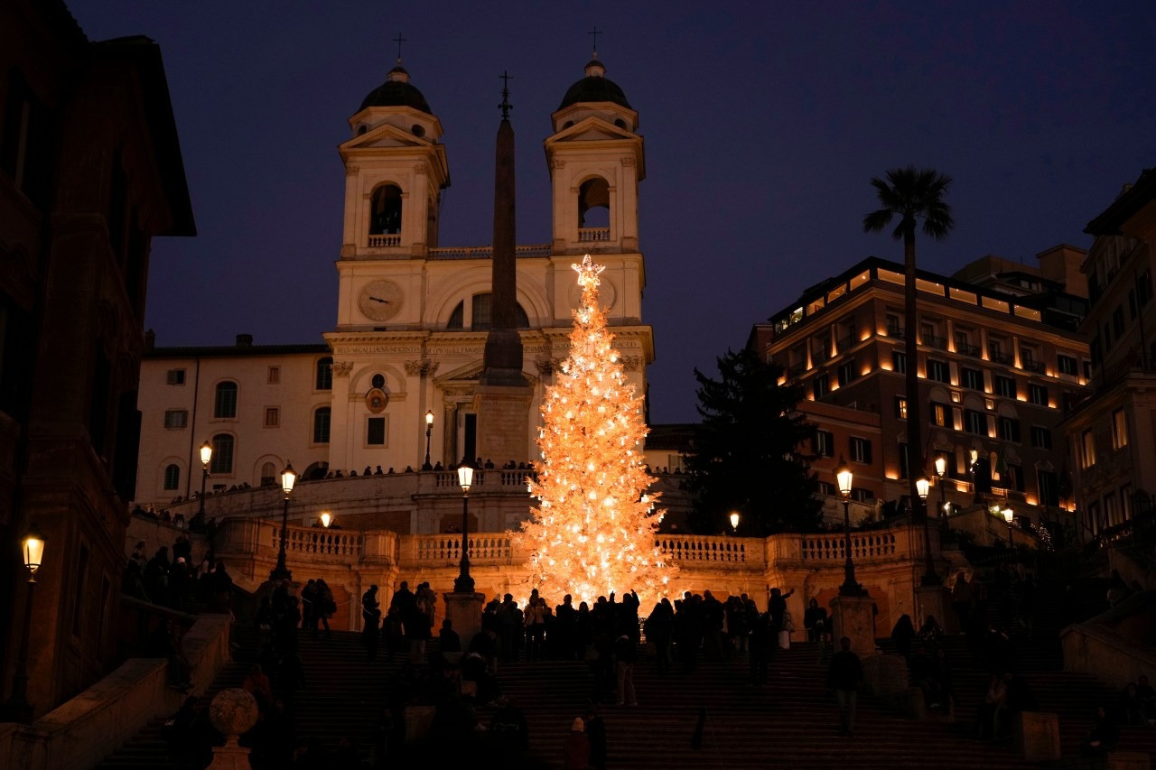 Du khách chụp ảnh bên cây thông ở Rome (Ý). Ảnh: AP