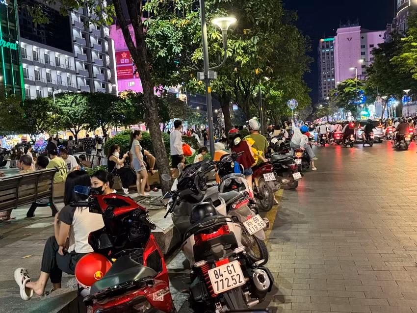 Người dân đi phố đi bộ Nguyễn Huệ sắp hết cảnh vừa chơi, vừa giữ xe máy. Ảnh: ĐÀO TRANG