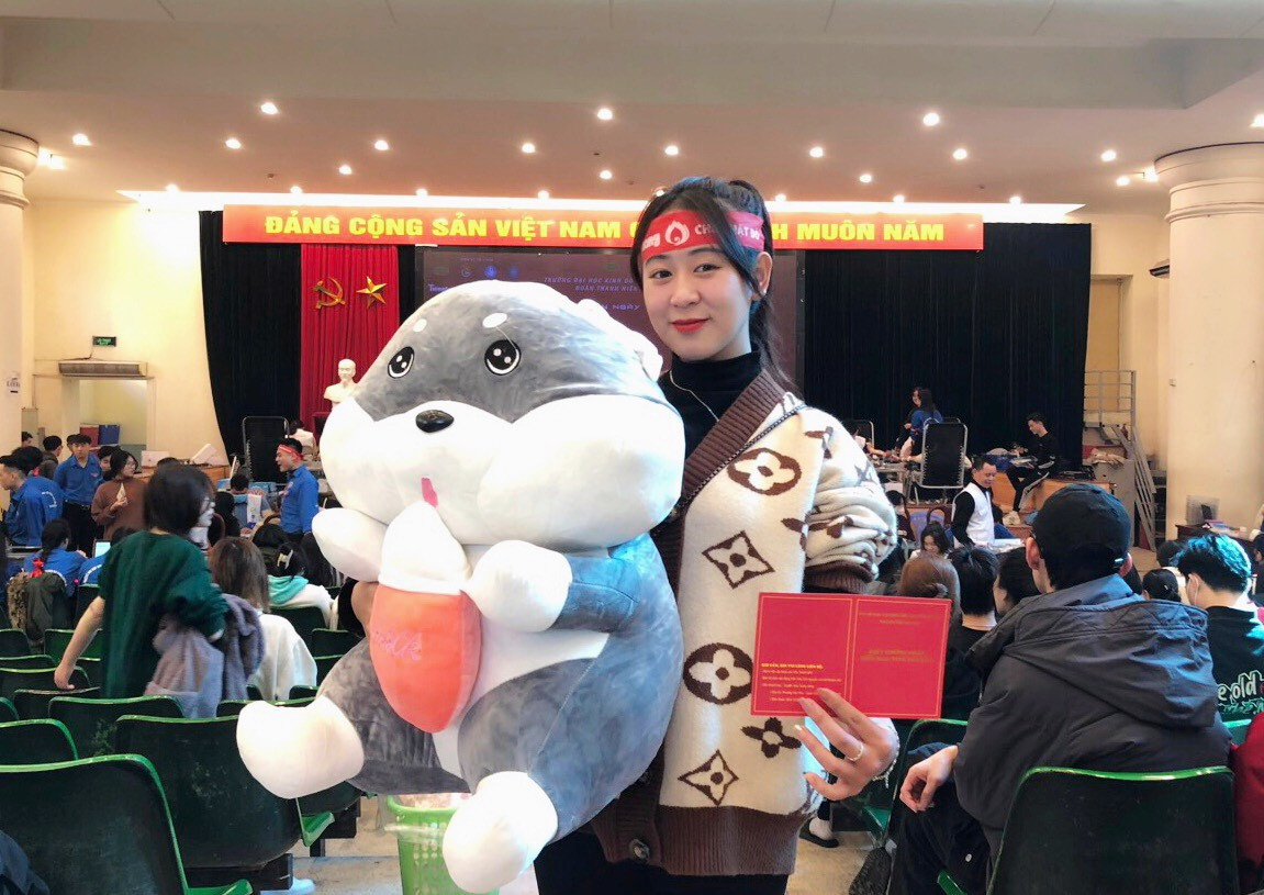 Em Giang Huyền Thương chụp hình cùng quà tặng và chứng nhận hiến máu tình nguyện tại chương trình.
