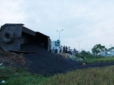 Nhựa đường từ trong thùng xe đổ hết xuống ruộng. Ảnh: Trường Phong. Nhựa đường từ trong thùng xe đổ hết xuống ruộng. Ảnh: Trường Phong