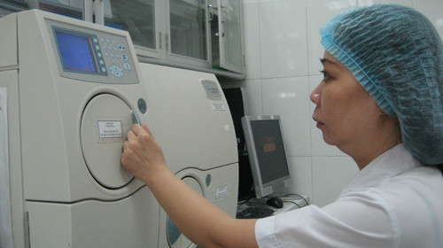 Cán bộ phòng xét nghiệm Bệnh viện Bệnh nhiệt đới T.Ư làm việc trên máy định danh vi khuẩn. Ảnh: Lan Anh (Tuổi Trẻ)