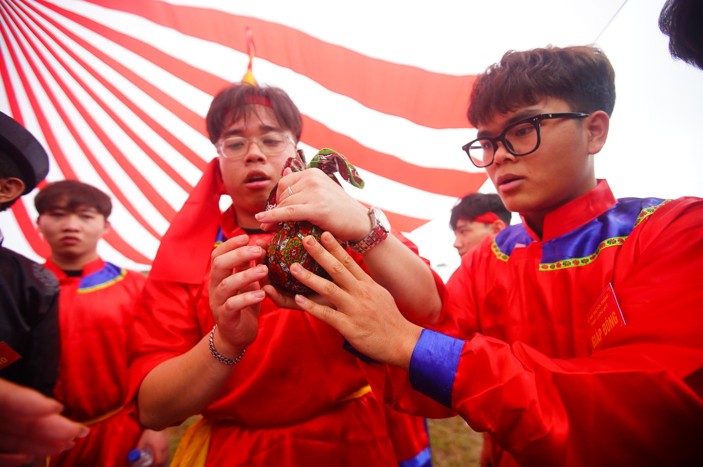 Cơm sau khi chín dẻo sẽ được trai tráng dùng vải nắm tròn.