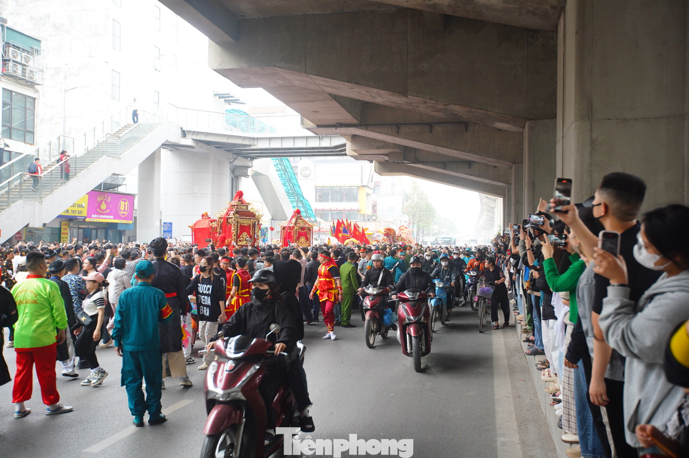 Người dân đi qua, tò mò đứng lại hai bên đường, dải phân cách để quay phim chụp ảnh đoàn rước kiệu đặc biệt này.