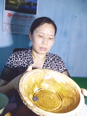 Bà Lê Thị Chung, PGĐ Bảo tàng Quảng Ngãi, xem xét cổ vật. Ảnh: Thanh Trung
