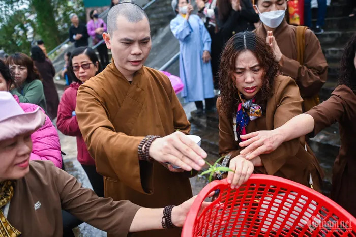 Sư thầy Thích Khải Thành đọc kinh chú trước khi thả cá xuống nước.