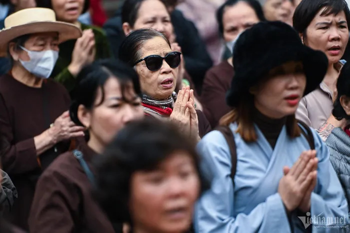 Trong khi cá được đưa xuống sông, nhiều phật tử đứng trên bờ chắp tay đọc kinh cầu khấn.