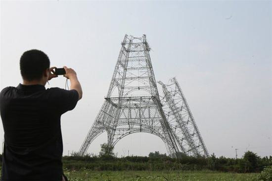 Một người đàn ông chụp ảnh tháp truyền hình gãy. Ảnh: CFP