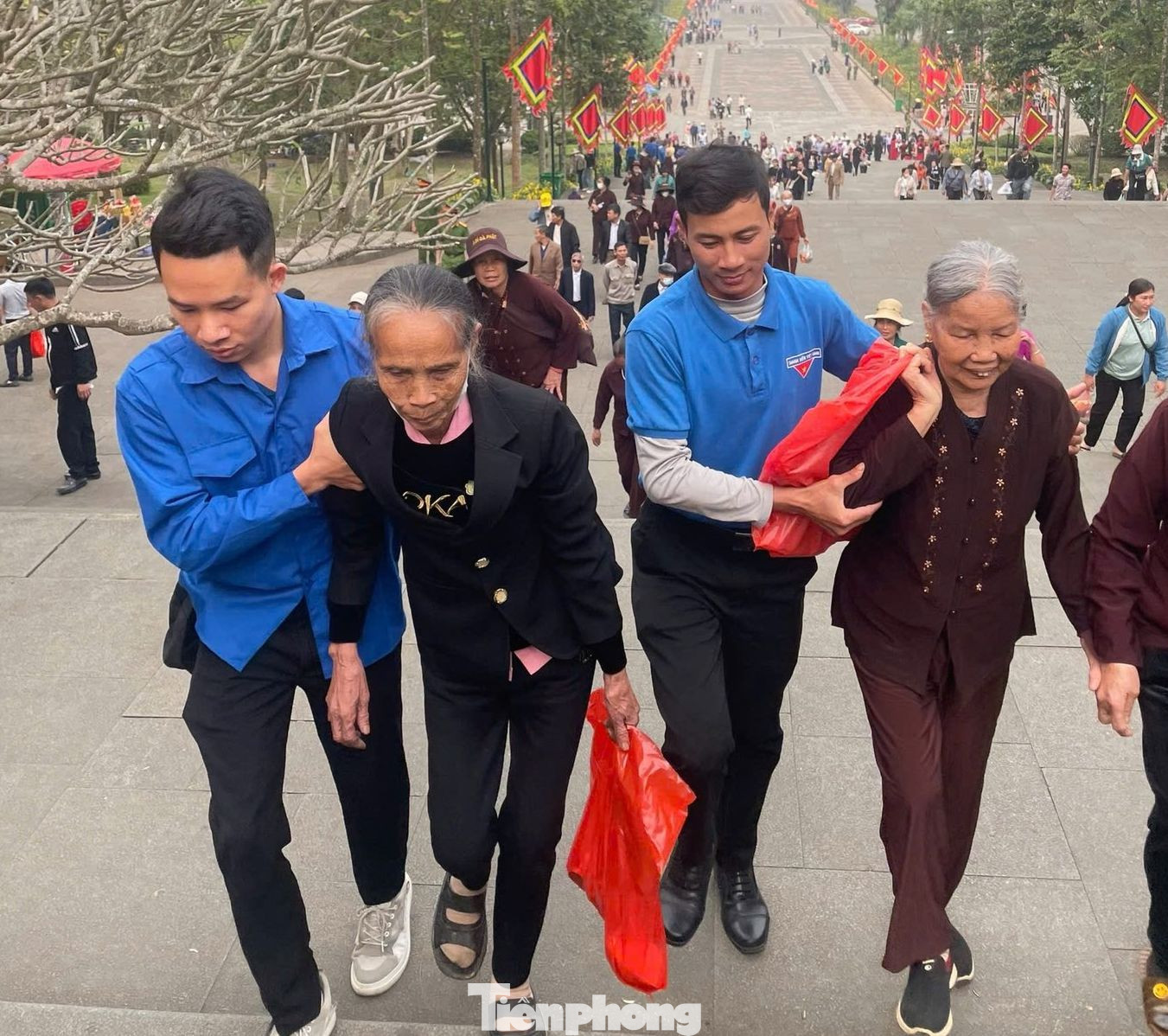 Đoàn viên thanh niên hỗ trợ người dân về Đền Hùng hành lễ.