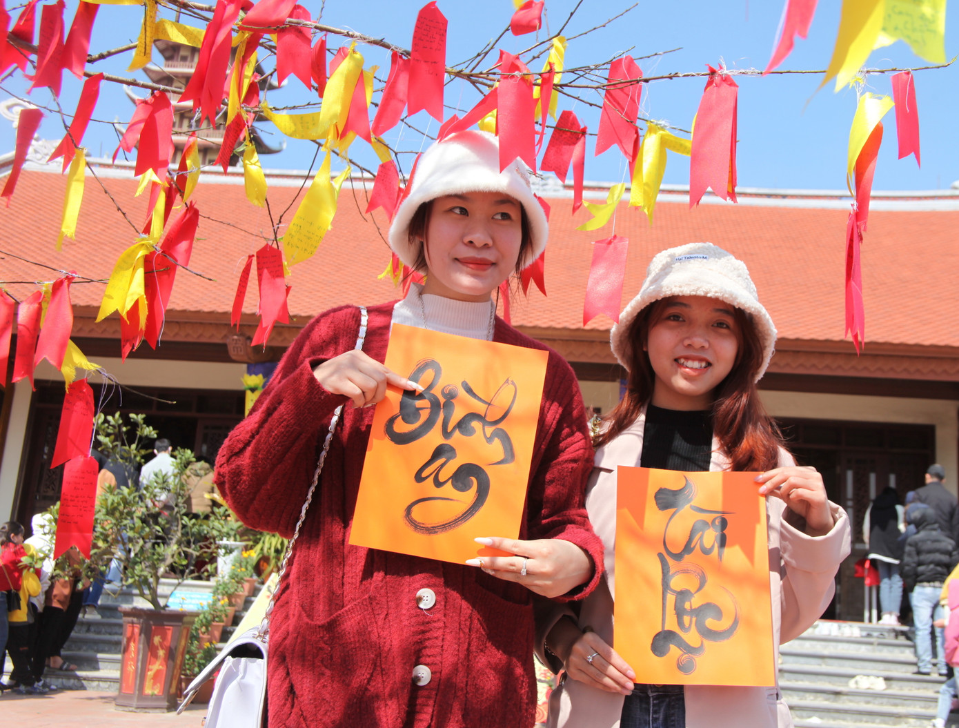 Hai bạn Lê Thị Ngọc (19 tuổi) và Hoàng Linh Trang (19 tuổi, trú huyện Hưng Nguyên) vui mừng và khoe đã may mắn khi được xin 2 chữ "bình an, tài lộc" tại chùa Đại Tuệ ngày đầu năm.