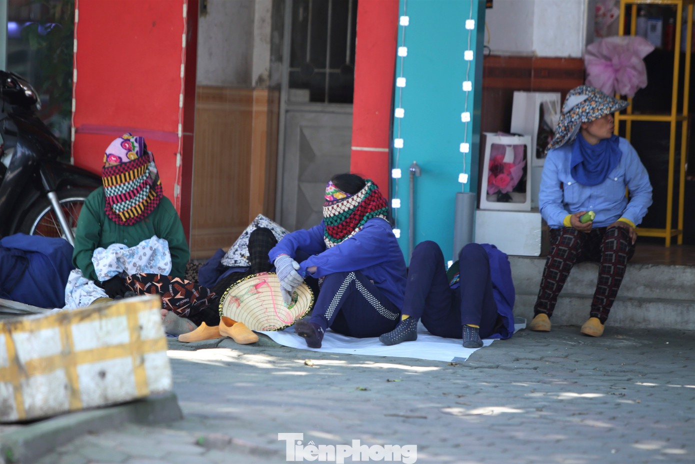 Những người phụ nữ cửu vạn tranh thủ nghỉ trưa ở các khu vực có bóng cây ở đường Nguyễn Du. Nắng nóng khiến họ phải làm từ sớm và dễ xuống sức khi dần trưa.