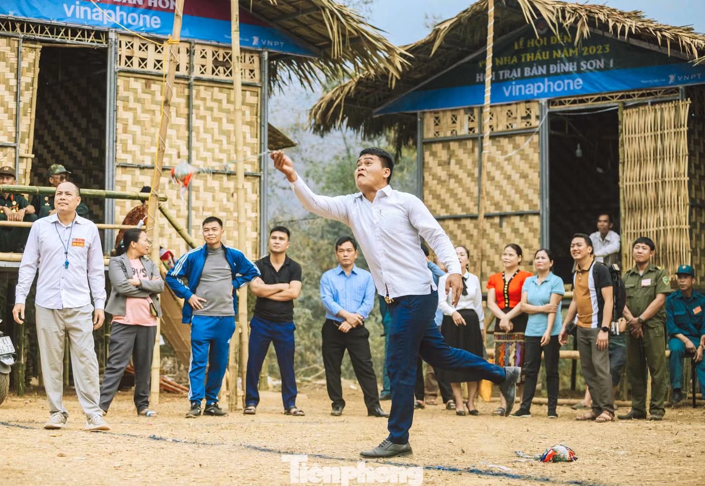 Người chơi cầm gần cuối đoạn dây vải quay quả còn vài vòng theo chiều kim đồng hồ rồi mới tung lên để quả còn bay lọt qua vòng tròn là thắng cuộc. Ai ném được còn lọt qua vòng trên cao được xem như là người sẽ có nhiều may mắn. (Ảnh: Rạng Đông).