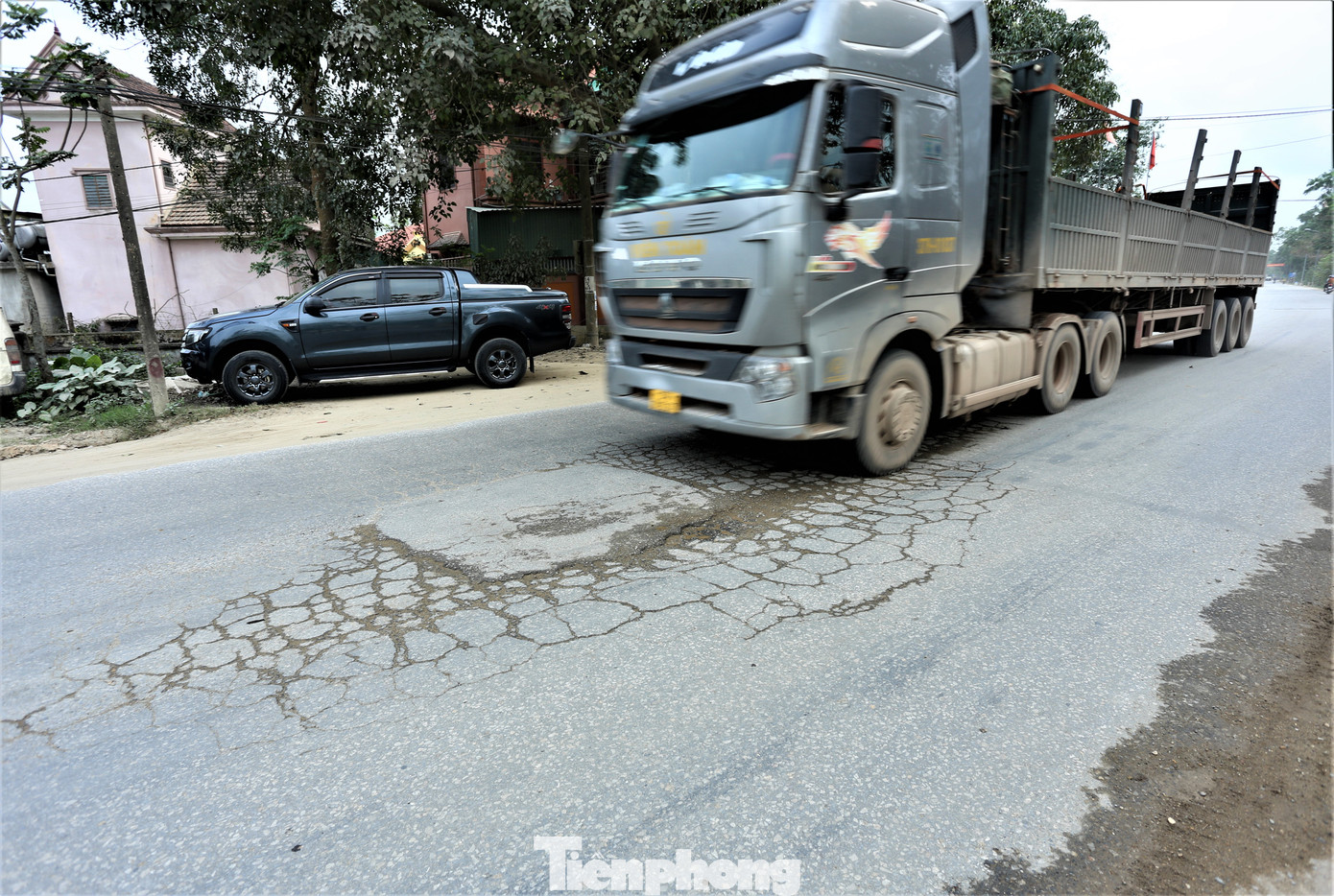 Xe tải trọng lớn chạy qua thường xuyên đã khiến mặt đường hư hỏng, rạn nứt. 2 bên đường đất cát rơi vãi dày đặc.