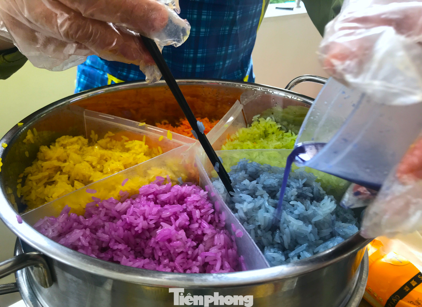 Anh Lê Văn Lĩnh đang thực hiện nấu món xôi ngũ sắc. Để có được màu sắc đẹp cho món xôi, anh Lĩnh phải chuẩn bị nước màu từ trước. "Nước màu này được đội thi chúng tôi xay từ các loại củ quả tự nhiên gồm: hoa đậu biếc, quả gấc, lá nếp xanh, lá cẩm và nghệ. Thời gian có hạn nên mỗi người chia nhau làm mỗi món. Chi phí cũng giới hạn nên mọi người cân nhắc làm món nào cho hợp lý vừa nhanh, vừa đẹp vừa hợp giá tiền", anh Lĩnh chia sẻ. Anh Lê Văn Lĩnh đang thực hiện nấu món xôi ngũ sắc. Để có được màu sắc đẹp cho món xôi, anh Lĩnh phải chuẩn bị nước màu từ trước. "Nước màu này được đội thi chúng tôi xay từ các loại củ quả tự nhiên gồm: hoa đậu biếc, quả gấc, lá nếp xanh, lá cẩm và nghệ. Thời gian có hạn nên mỗi người chia nhau làm mỗi món. Chi phí cũng giới hạn nên mọi người cân nhắc làm món nào cho hợp lý vừa nhanh, vừa đẹp vừa hợp giá tiền", anh Lĩnh chia sẻ.