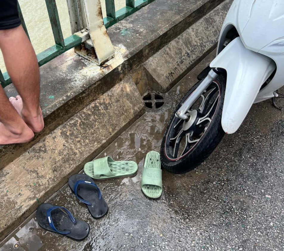 Đôi dép cùng chiếc xe máy mà nam thanh niên T. để lại trên cầu rồi nhảy xuống sông Lam tự tử.