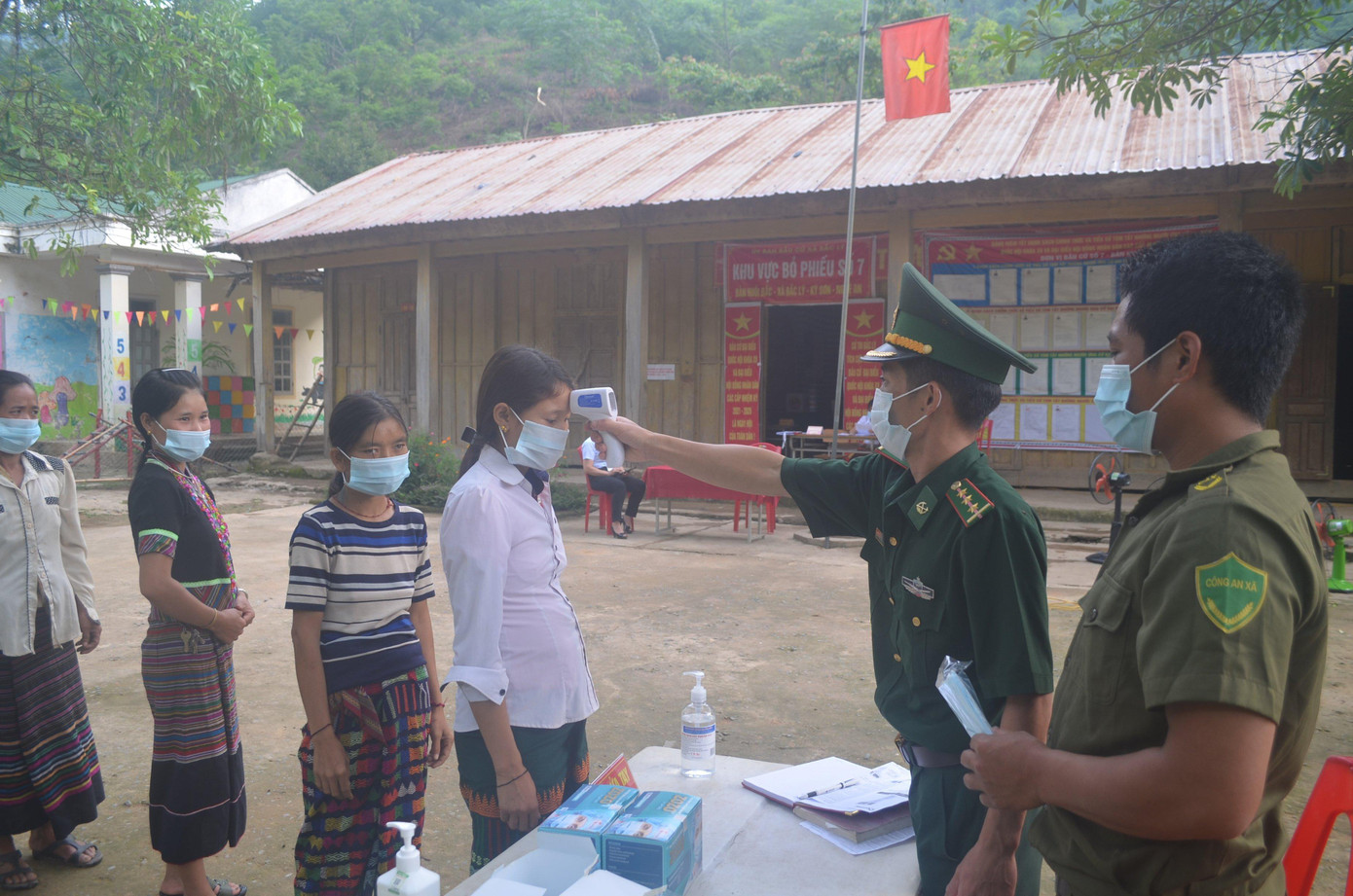 Trước khi vào hội trường bỏ phiếu, cử tri được đo thân nhiệt, sát khuẩn và đeo khẩu trang để phòng, chống dịch bệnh COVID-19.