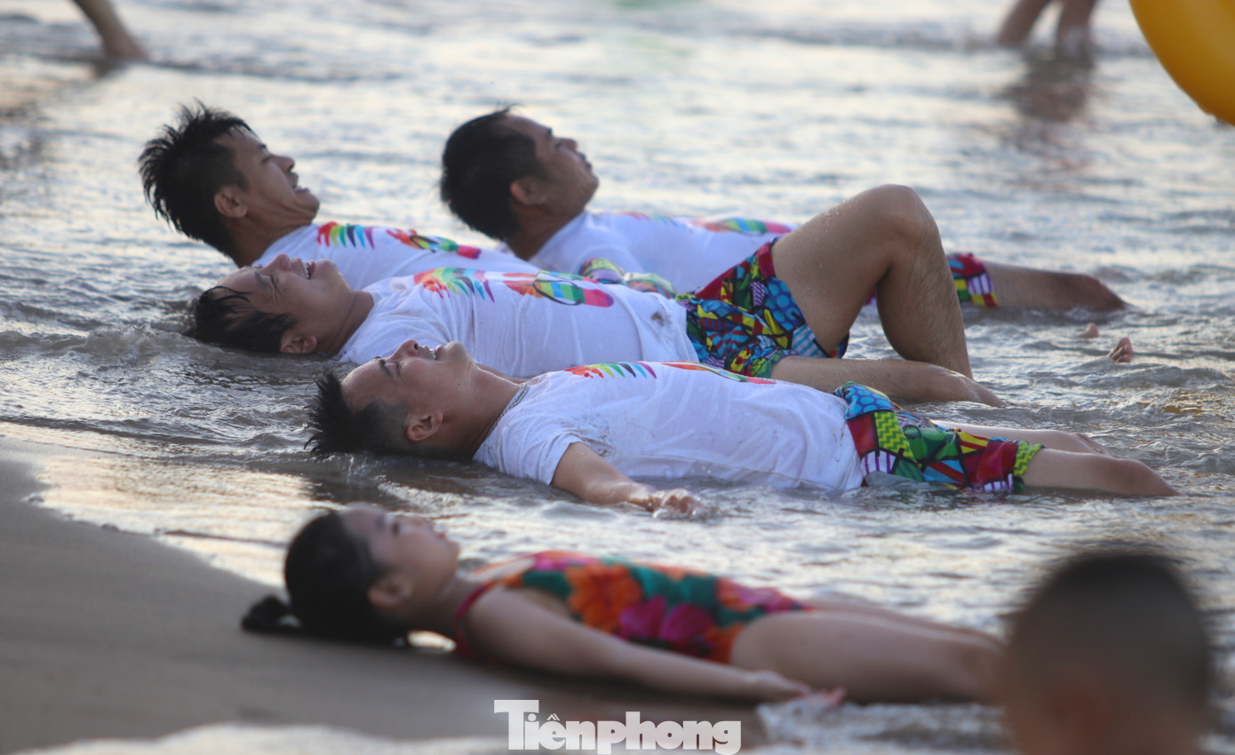 Nhiều người thả mình tự do nằm trên bãi cát để sóng đánh tạo cảm giác lạ.