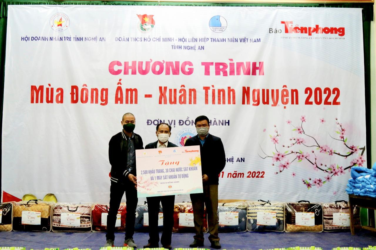 Nhà báo Trần Quang Long - Trưởng Đại diện báo Tiền Phong tại Nghệ An, Hà Tĩnh trao biển tượng trưng các món quà cho đại diện UBND xã Tiền Phong.
