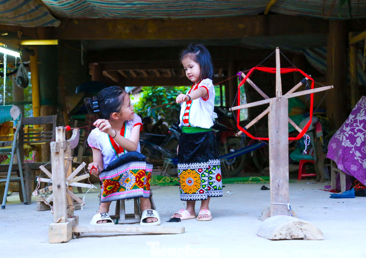 Tranh thủ những ngày được nghỉ học, hai chị em Lô Thị Yến Hương (trái) và Lô Thị Yến Vy ở bản Na, xã Hữu Lập (Kỳ Sơn) được học kỹ năng cuộn chỉ, dệt vải, thêu váy.