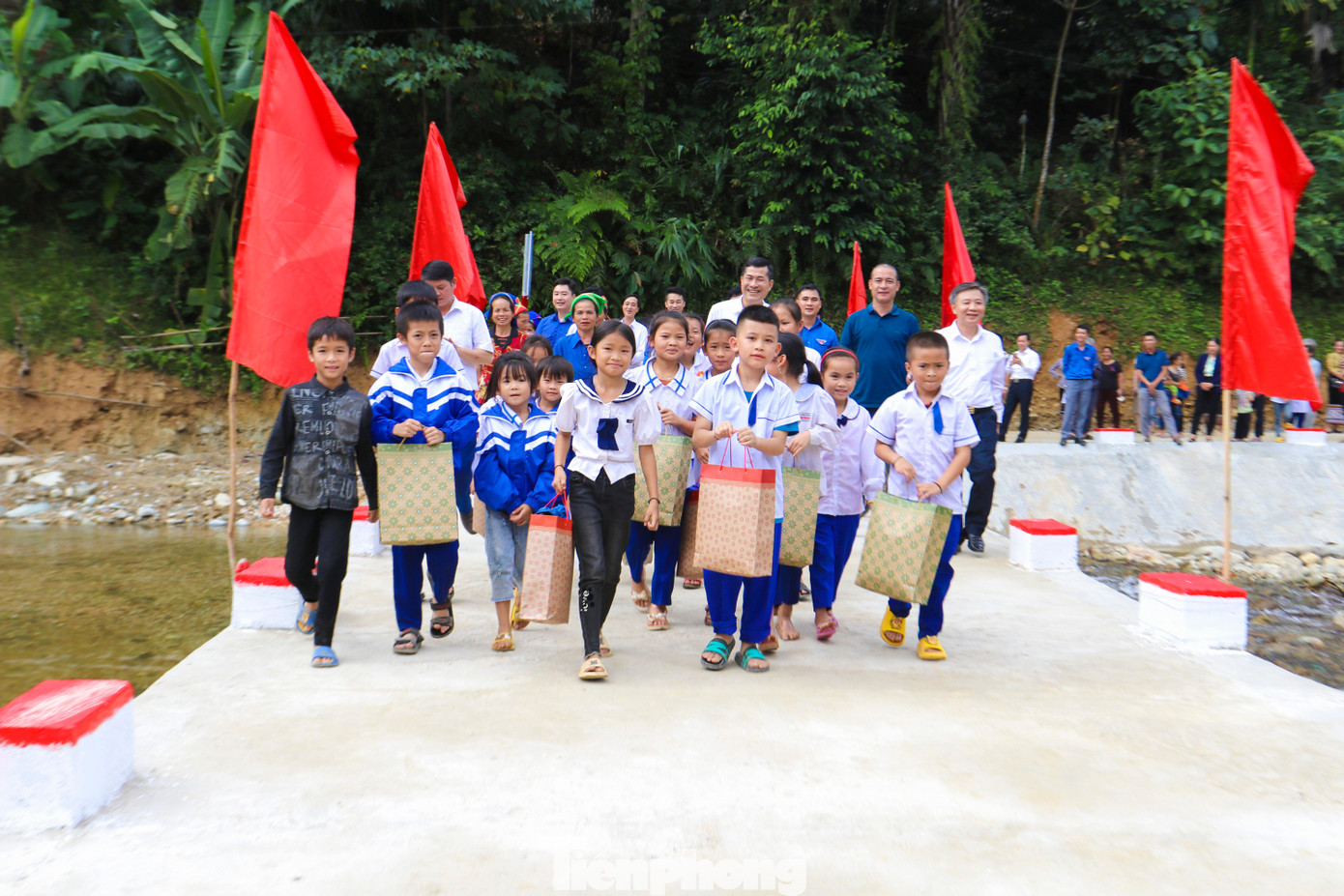 Các em học sinh đi trên chiếc cầu mới.