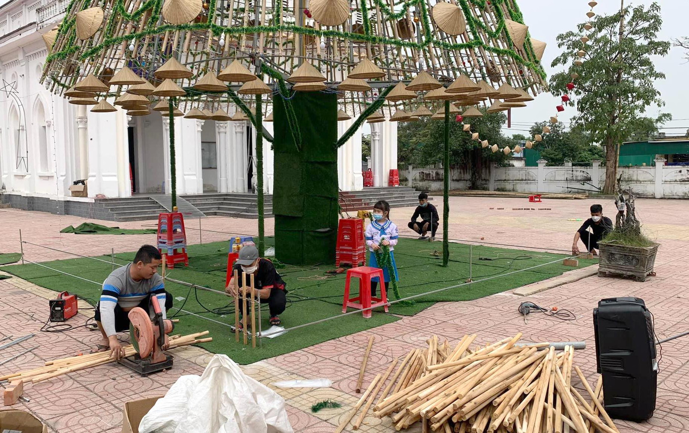 Cây thông có 3 tầng trụ trên 1 cột thép vững chắc, kết hợp cùng hàng nghìn cây nứa, hàng nghìn dây led, dây kim tuyến... Điểm nhấn trong đó là hàng trăm chiếc nón lá được gắn xung quanh để trang trí.