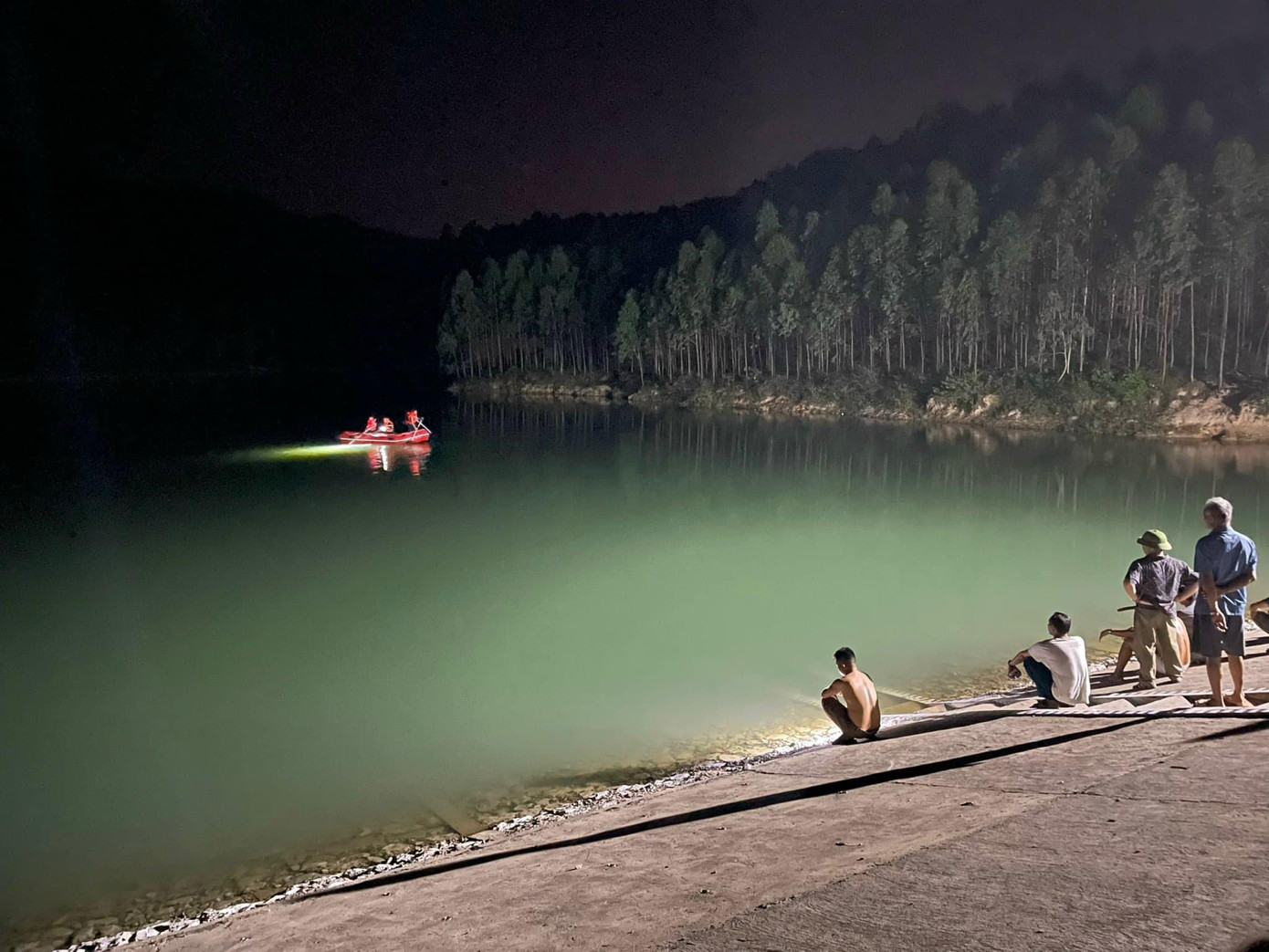 Lực lượng chức năng đang tìm kiếm nạn nhân Q. trên đập nước.