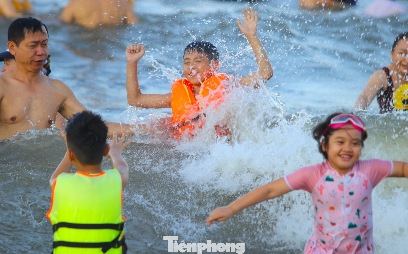 Nhiều em nhỏ, người lớn thỏa thích vui đùa cùng con sóng.