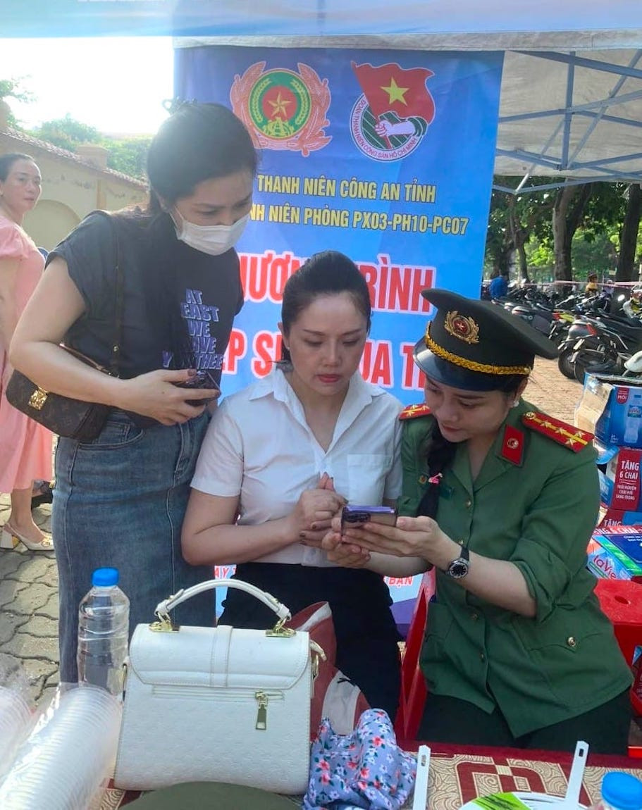 Thấy có điểm hỗ trợ cài đặt tài khoản định danh điện tử, nhiều phụ huynh đưa con đi thi đến nhờ các cán bộ công an hỗ trợ.