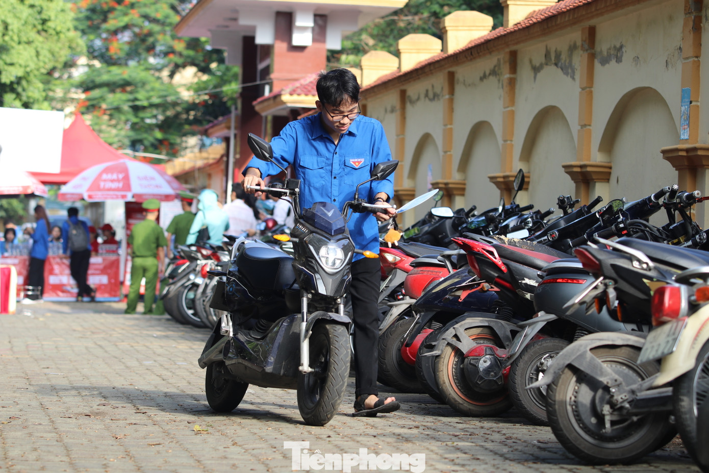Các đoàn viên hỗ trợ xếp xe, trông giữ xe cho các em thí sinh vào trường. &quot;Trời hôm nay nắng nên khá mệt. Chúng em sẽ cố gắng hết mình để hỗ trợ các thí sinh đến trường thi&quot;, em Hoàng Đức Tài (học sinh lớp 11A5 trường THPT chuyên Phan Bội Châu chia sẻ và cho biết, sáng sớm em cùng các bạn đoàn viên đến trường từ lúc 5h sáng để bắt đầu công việc.
