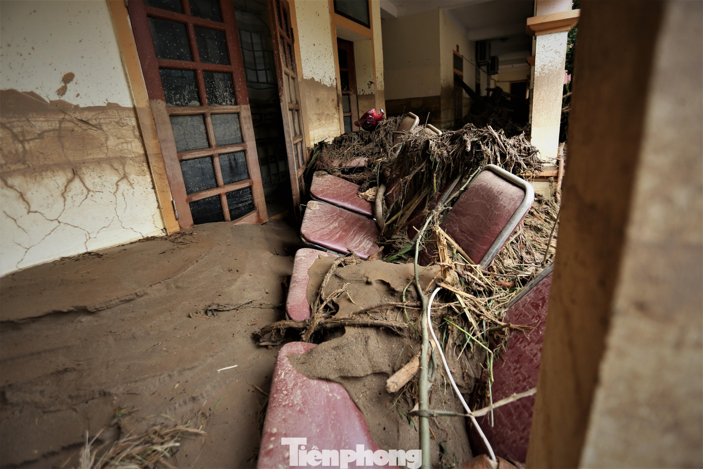 Ghế và nhiều tài sản trong một trụ sở hành chính bị cuốn ra ngoài, dính chặt vào bùn.