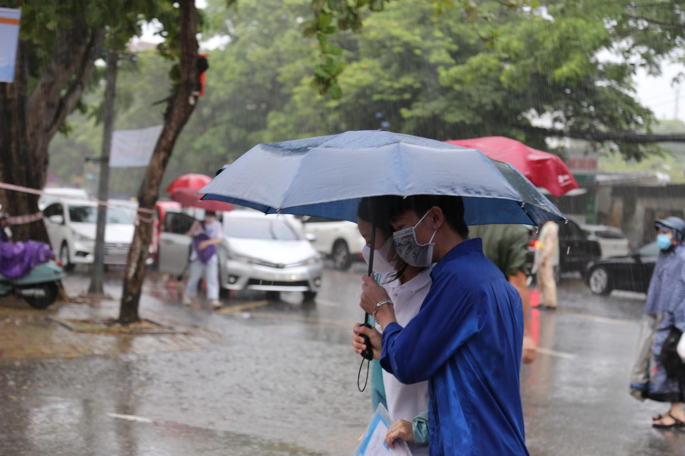 Ảnh hưởng của áp thấp nhiệt đới, ngày đầu tiên diễn ra kỳ thi tốt nghiệp THPT năm 2021, địa bàn Nghệ An có mưa nên từ sáng sớm, đoàn viên thanh niên tình nguyện đã chuẩn bị ô che mưa, đón đưa các sĩ tử vào phòng thi không bị ướt.