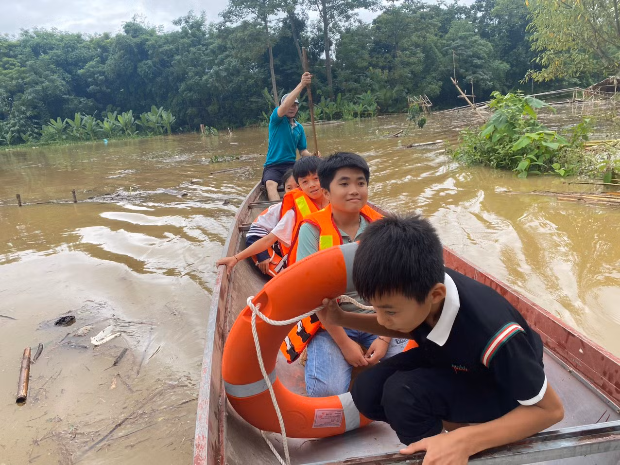 Đoàn viên, thanh niên huyện Con Cuông chèo thuyền đưa học sinh đến nơi an toàn.