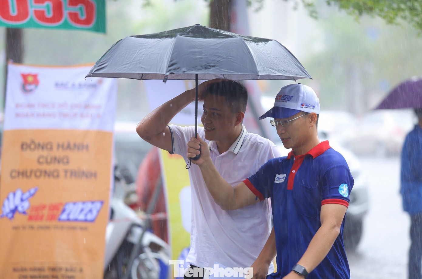 Cơn mưa lớn khiến cả tình nguyện viên và thí sinh cũng bị ướt.