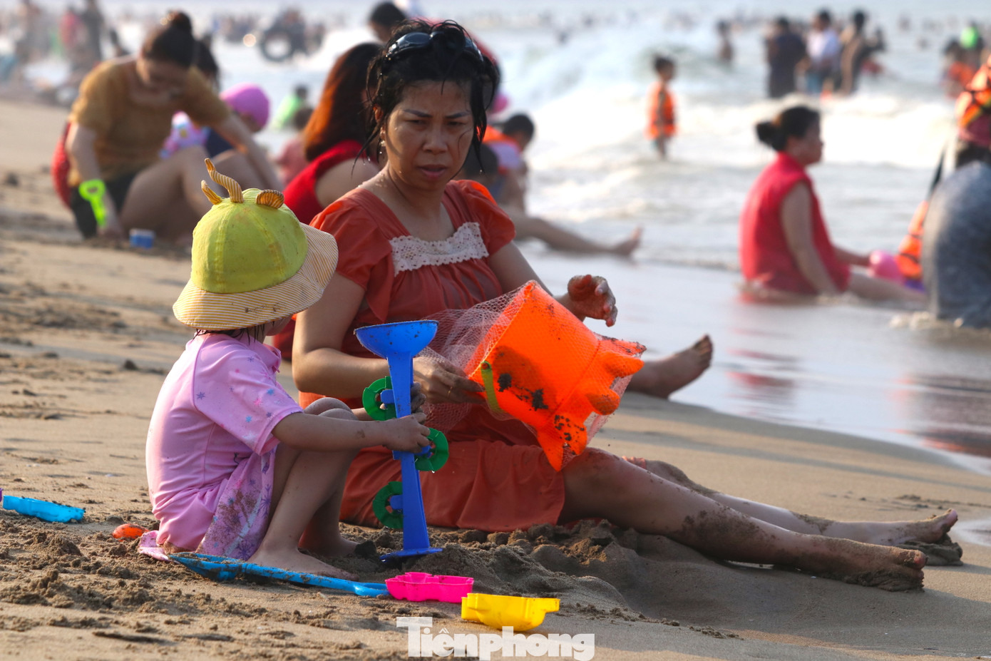 Nhiều em bé mang cả đồ chơi xuống để chơi cát và mang theo phao cá nhân để chơi đùa với sóng.