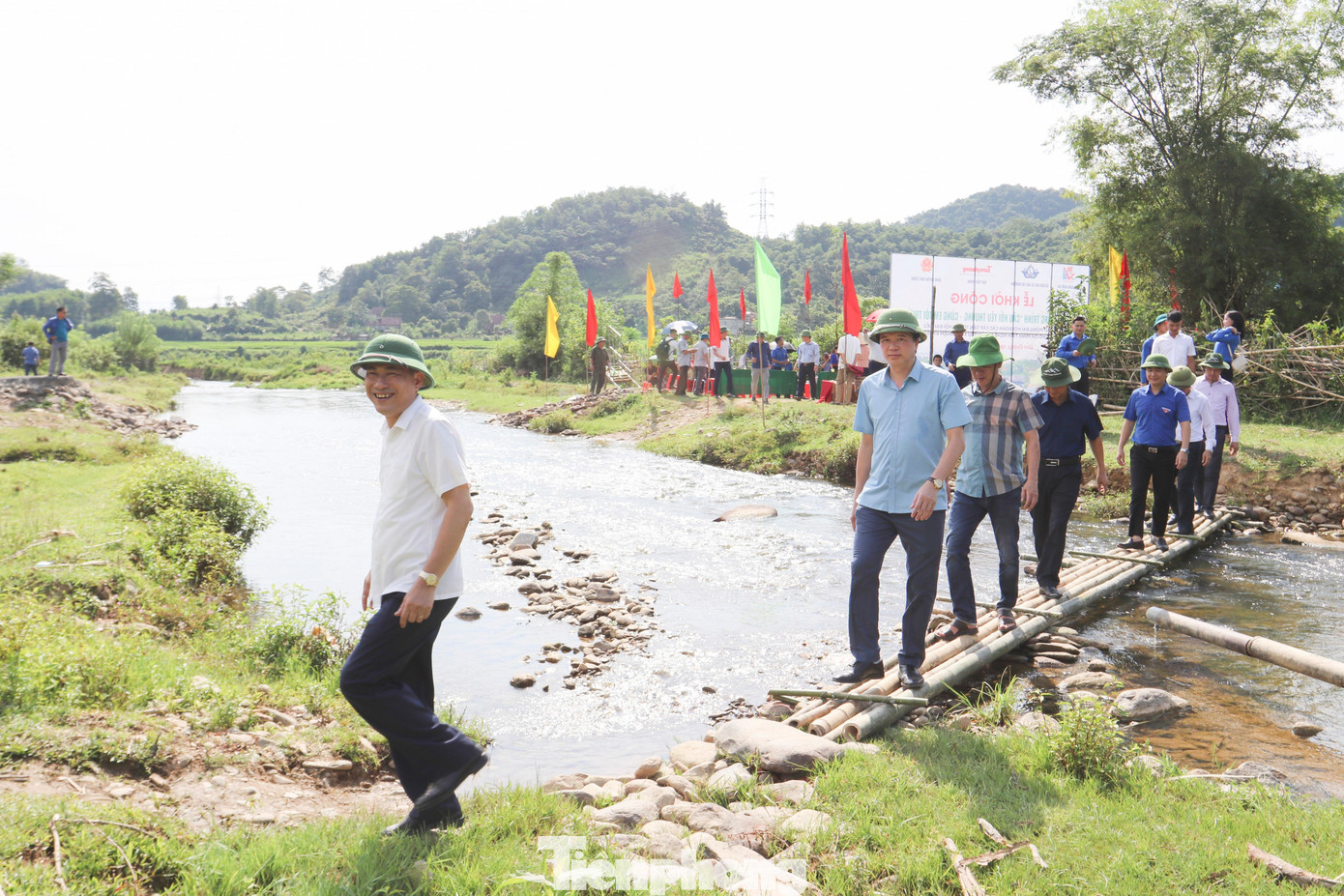GS-TS Thái Văn Thành - Giám đốc Sở GD&amp;ĐT Nghệ An cùng các đại biểu, người dân đi qua cây cầu tạm ở suối Khe Chai, nơi sẽ được xây dựng cây cầu mới.