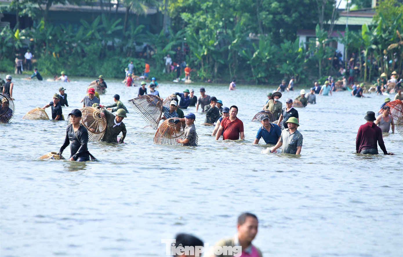 Sau tiếng trống khai hội, hơn 600 “nơm thủ” ào xuống hồ, dùng nơm, vợt đã chuẩn bị để săn cá.