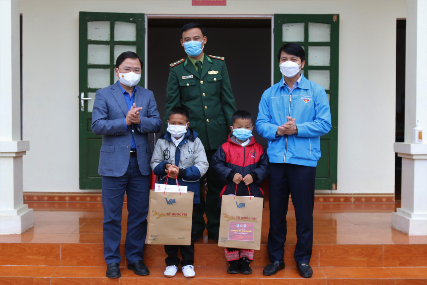 Anh Nguyễn Anh Tuấn và anh Nguyễn Ngọc Lương tặng quà hai con nuôi của Tổ công tác Huồi Pốc.